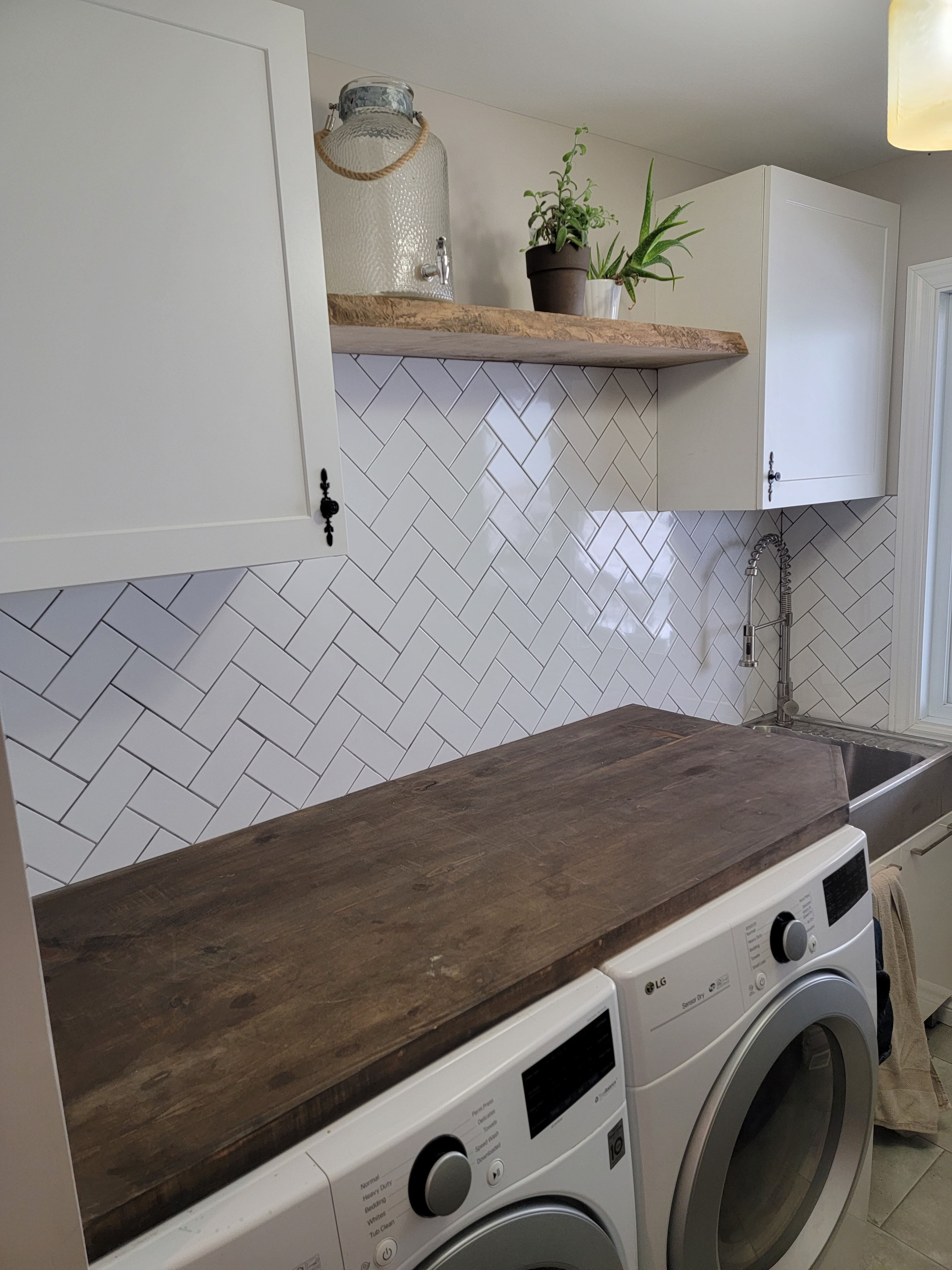 Custom laundry room with herringbone backsplash