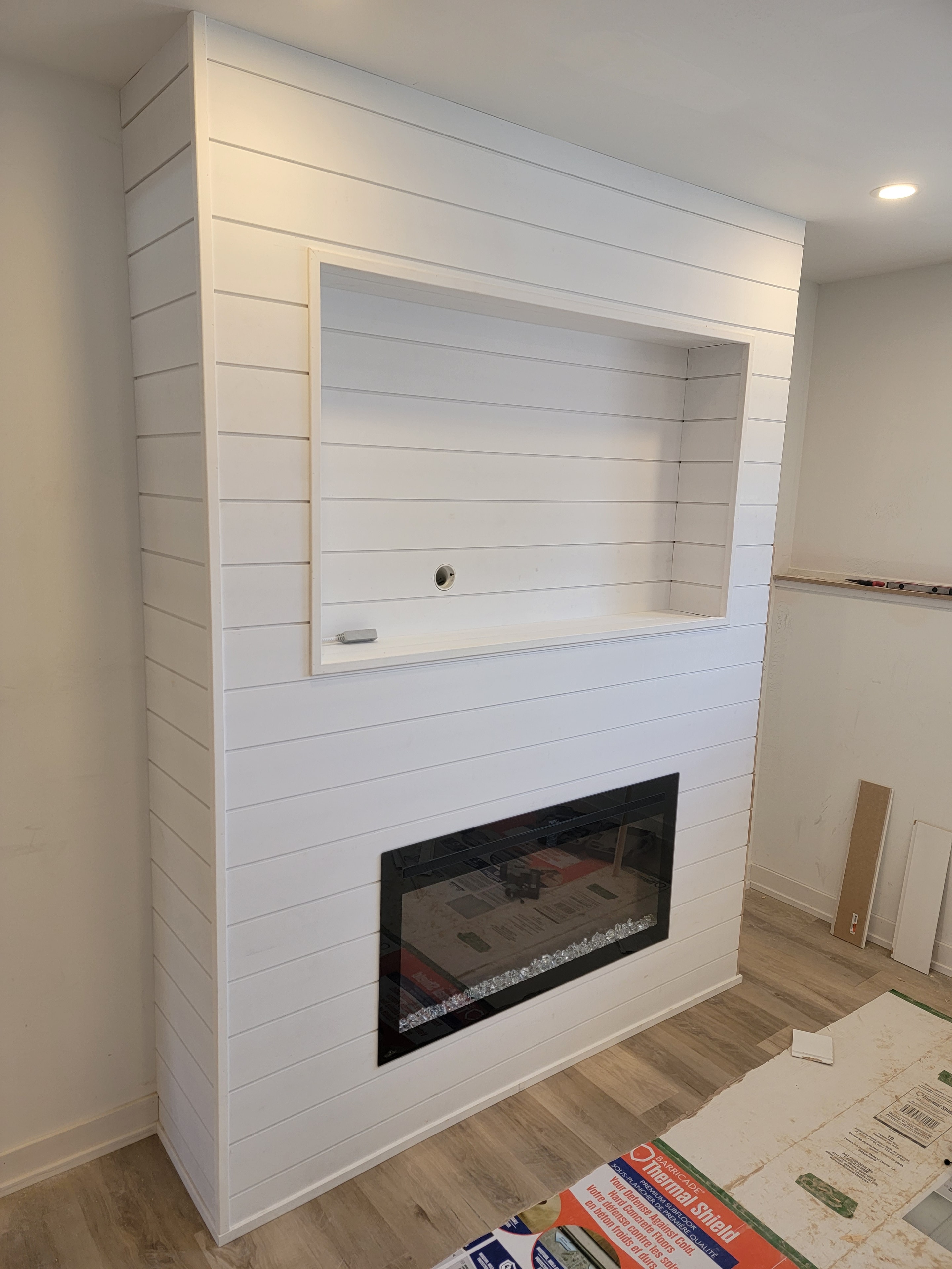 White shiplap fireplace surround with built-in shelving